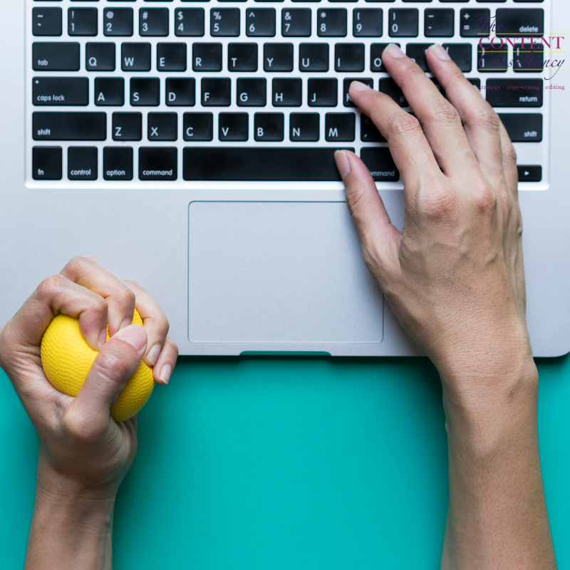 Hand on laptop keyboard and squeezing a stress ball